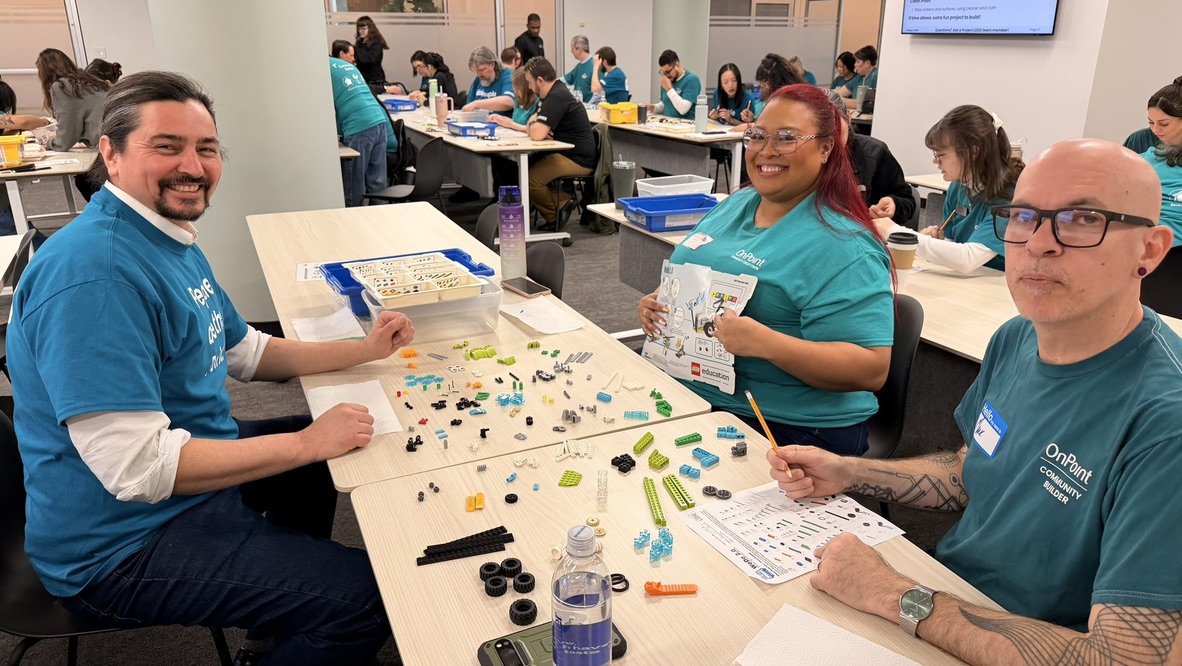 Volunteers smiling while sorting LEGO parts at a Project LEDO event
