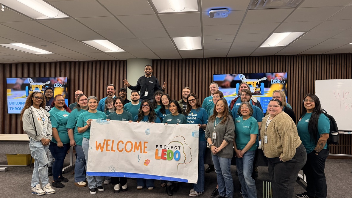 OnPoint Community Credit Union volunteers with a Welcome Project LEDO banner